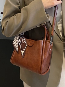 Retro brown PU leather bucket bag with top handle and silk scarf on green suit
