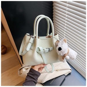 Détail du sac à main tissé vert menthe avec pendentif chiot en peluche et bandoulière