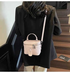 Fashionable pink box-style bag with quilted diamond pattern shown on a model