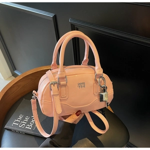 Détail du mini sac Boston rose avec logo en métal et cadenas décoratif sur le devant