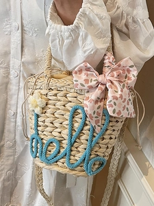 Handmade woven straw bucket bag with blue hello text and floral ribbon for beach vacation