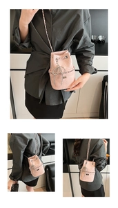Detailansicht der rosa gesteppten Beuteltasche mit Kettenriemen und Metallschleifen-Anhänger