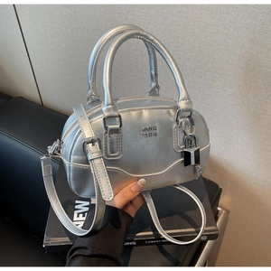 Détail du sac Boston argenté avec fini métallique, gaufrage COIN RDN et cadenas
