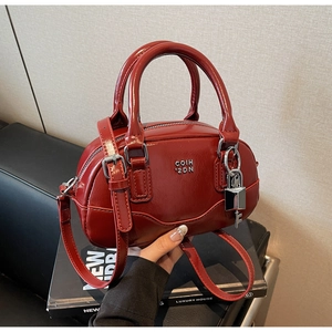 Détails du sac Boston bordeaux brillant avec serrure métallique et poignée