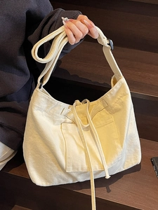Minimalist beige canvas tote bag with large capacity and adjustable shoulder strap