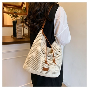 Detail shot of hollow crochet knit tote bag with brown leather strap and texture