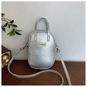 Detail of silver matte crossbody phone bag with BURGMHN logo on a wooden surface