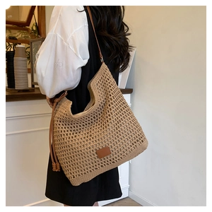Detail of hollow woven tote bag with brown leather straps and spacious interior lining