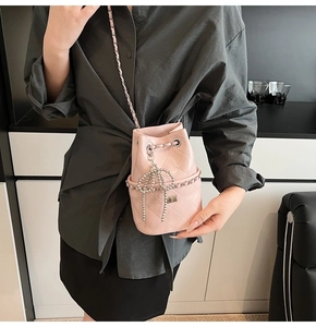 Detail einer rosa gesteppten Beuteltasche mit Perlen-Schleifen-Anhänger und Kette