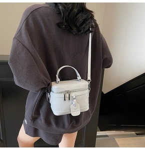 Detailed back view of a white quilted box bag styled with a dark textured outfit
