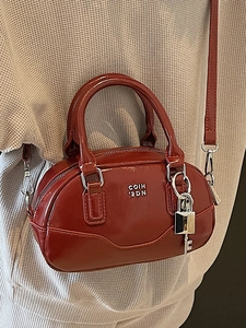 Sac Boston bandoulière en cuir verni rouge foncé avec pendentif cadenas argenté élégant