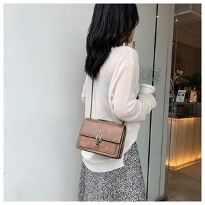 Detail shot of the Maillard brown vintage chain bag with sleek parallel metal bar locks