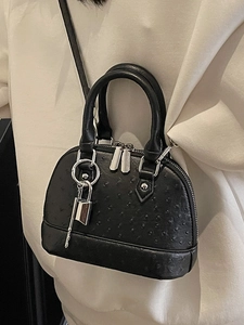 Elegante borsa a conchiglia nera con texture a pois e dettaglio lucchetto argentato