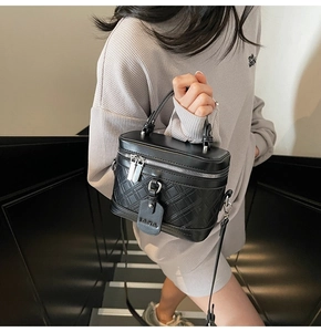 Chic black box crossbody bag with quilted texture shown by a model on stairs