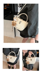 Detail view of cream lychee texture handbag with silver lock and plush bear charm