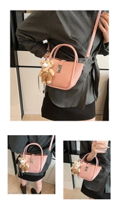 Detail of pink lychee leather bucket bag with silver lock and cute bear charm pendant