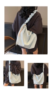 Detail of light blue hobo bag featuring pleated cloud strap and woven tassel charm