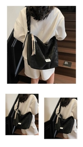 Detail of black tote bag with ruffled strap and tassel accent on white clothing