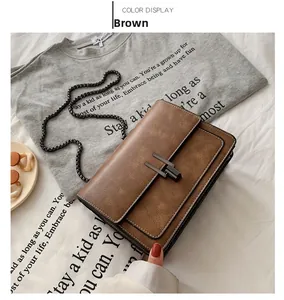 Detail of vintage brown chain bag with distressed texture and square metal buckle