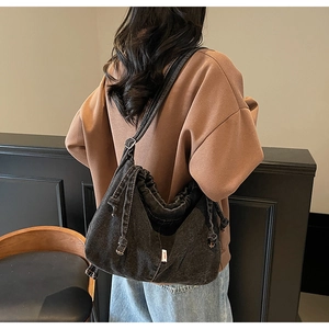 Détail du sac fourre-tout en denim noir vintage avec cordon de serrage sur un mannequin