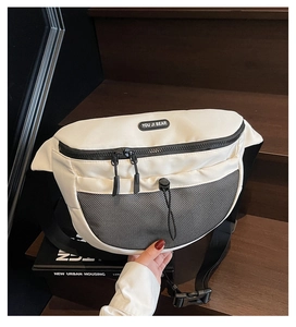 Détail d'un sac bandoulière beige en nylon avec poche en filet et étiquette de marque