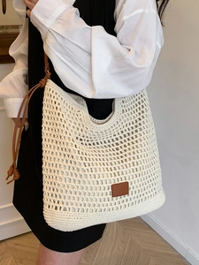 Minimalist woven crochet tote bag in beige with brown leather tag for casual summer vacations