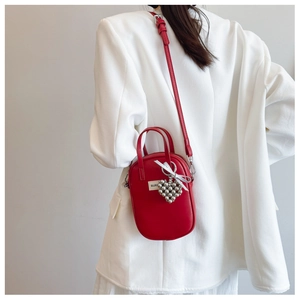 Chic red mini crossbody bag for women with silver heart charm and bow detail