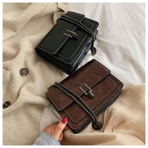 Detail of H-shaped metal buckles and chain straps on vintage brown and black crossbody bags