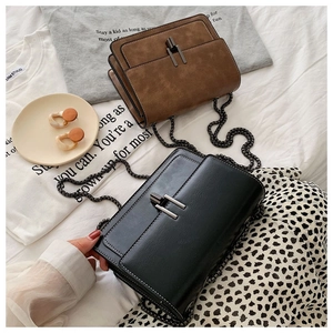 Detail view of brown and black leather crossbody bags with vintage metal chain straps