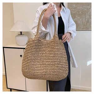 Large hand-woven straw shoulder bag for women shown in a lifestyle minimalist setting