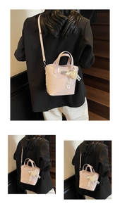 Detail of pink patent leather bucket bag with pearl heart charm and lace ribbon