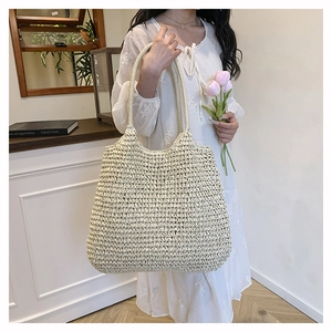 French style straw tote bag with woven shoulder straps shown in a minimalist interior