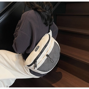 Détail du sac bandoulière crème avec panneaux en maille noire et sangle réglable