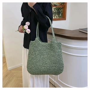 Detail showing green woven tote bag texture and long handles for shoulder carrying