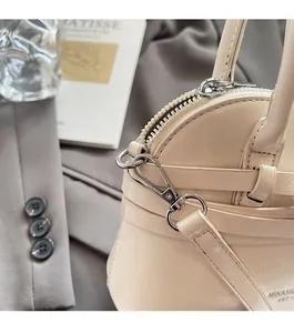 Detail of premium silver hardware and creamy white leather texture on shell handbag