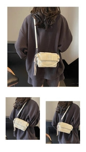 Close-up of cream woven texture small crossbody bag with metal ball pendant detail