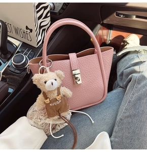 Pink lychee grain leather bucket bag with silver twist lock and cute teddy bear charm