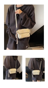 Detail of woven square crossbody bag in cream PU leather with pearl and tassel charms