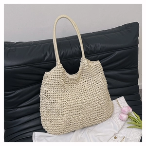 Detail of hand-woven texture on a creamy straw tote bag for casual summer vacations