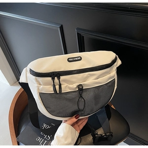 Détail d'un sac bandoulière blanc avec fermeture éclair noire et logo en caoutchouc