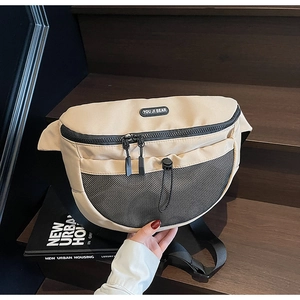 Vue détaillée du sac bandoulière beige avec poche en filet noir et cordon de serrage