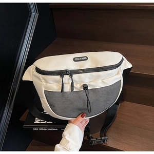 Vue détaillée du sac bandoulière blanc avec poche en filet noir et logo de marque