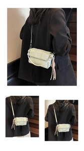 Detail of light green woven texture crossbody bag with coin logo and tassel charm