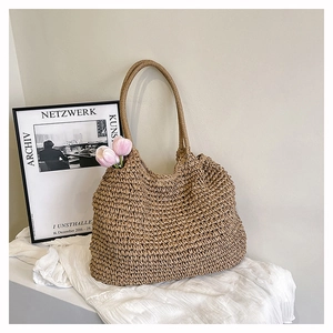 Detail of hand-woven straw tote bag with natural texture and elegant pink tulip decoration