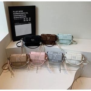Close-up of woven texture handbags in seven colors with knot detail and brand logo