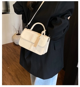 Détail du sac bandoulière blanc crème avec cuir lisse et texture tissée élégante