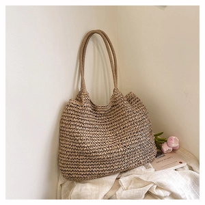 Detailed weave pattern of a beige straw tote bag with tulips in a rustic setting