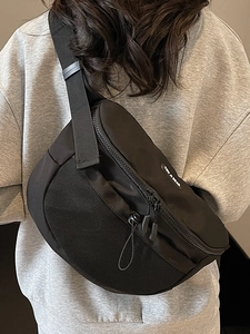 Sac bandoulière polyvalent en nylon noir avec sangle ajustable porté sur le dos