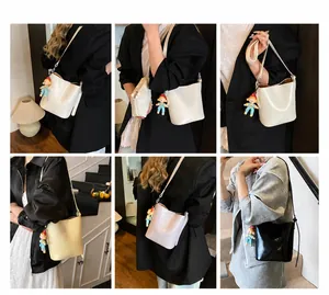 Polished faux leather bucket bag with cute charm shown in four stylish colors