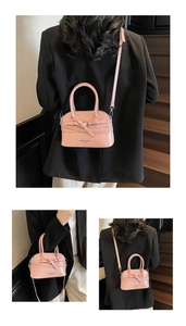 Detailed close-up of pink shell bag featuring sleek glossy finish and buckle decor